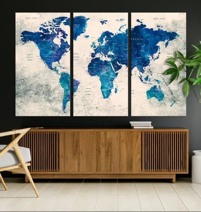 A Navy Blue Push Pin World Map Wall Art Canvas Print, displayed as a triptych on gallery-wrapped, museum-quality canvas, hangs on the wall.