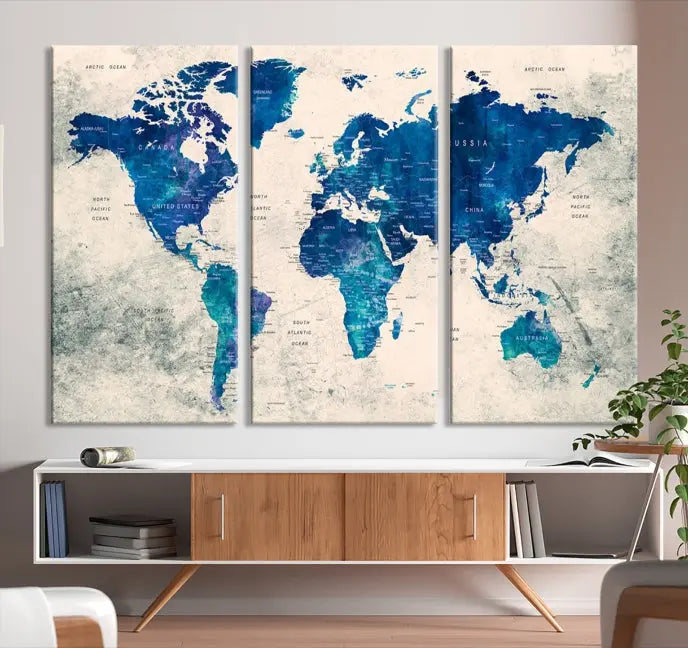 A Navy Blue Push Pin World Map Wall Art Canvas Print, displayed as a triptych on gallery-wrapped, museum-quality canvas, hangs on the wall.