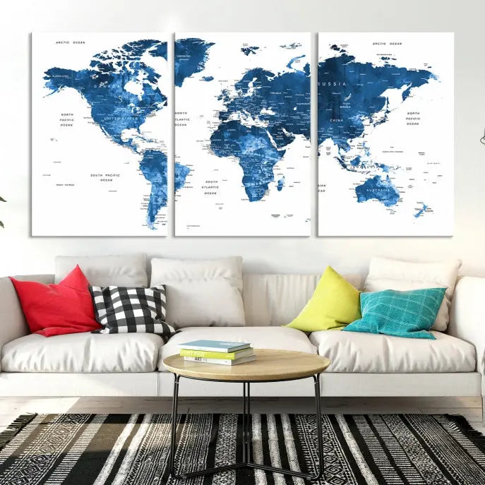 The Navy Blue Watercolor Push Pin World Map wall art canvas print, featuring a three-panel design and gallery wrapping on museum-quality canvas, adds an elegant touch to the room.