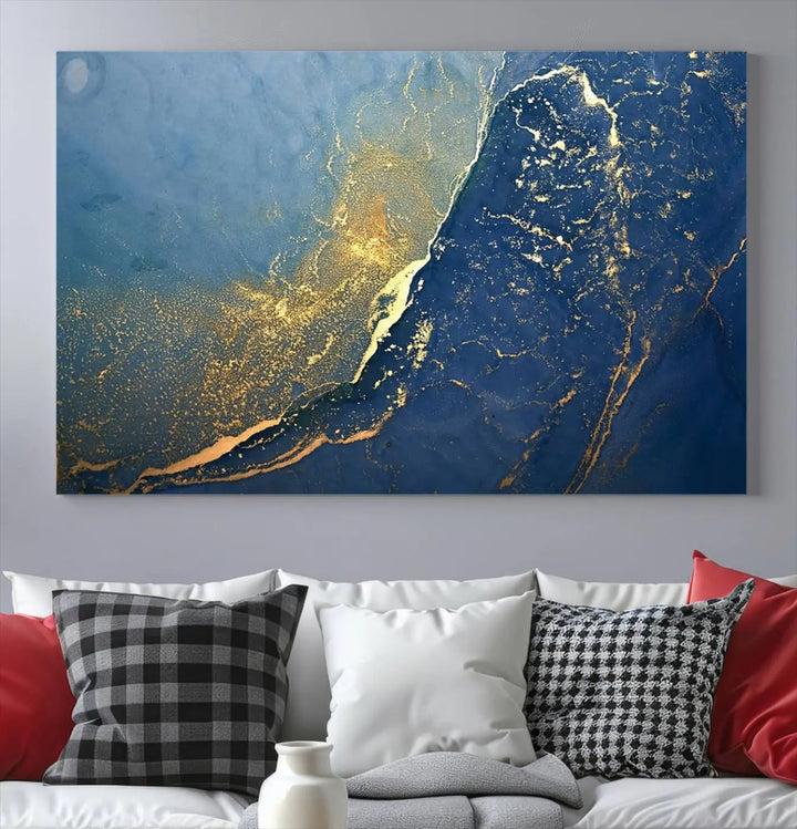 The Navy Blue Yellow Twinkle Wall Art Canvas Print, featuring an abstract design in gold and blue, enhances a modern living room as it adorns a white wall with its gallery-wrapped, museum-quality canvases for an exquisite touch.