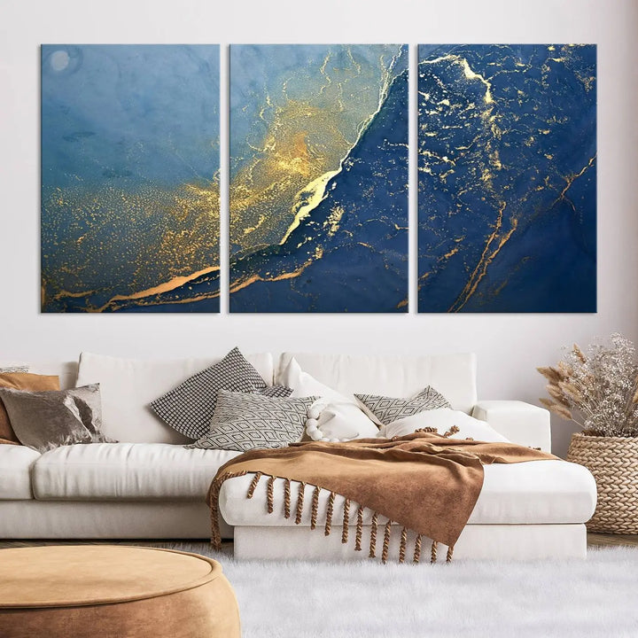 The Navy Blue Yellow Twinkle Wall Art Canvas Print, featuring an abstract design in gold and blue, enhances a modern living room as it adorns a white wall with its gallery-wrapped, museum-quality canvases for an exquisite touch.