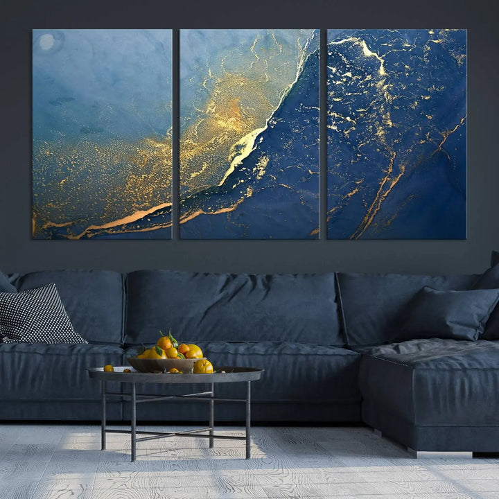 The Navy Blue Yellow Twinkle Wall Art Canvas Print, featuring an abstract design in gold and blue, enhances a modern living room as it adorns a white wall with its gallery-wrapped, museum-quality canvases for an exquisite touch.