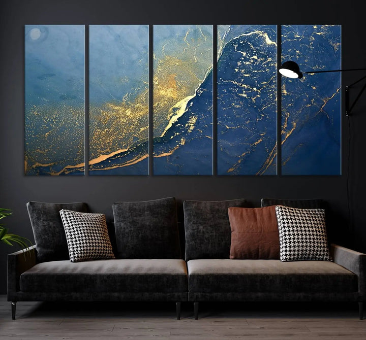 The Navy Blue Yellow Twinkle Wall Art Canvas Print, featuring an abstract design in gold and blue, enhances a modern living room as it adorns a white wall with its gallery-wrapped, museum-quality canvases for an exquisite touch.