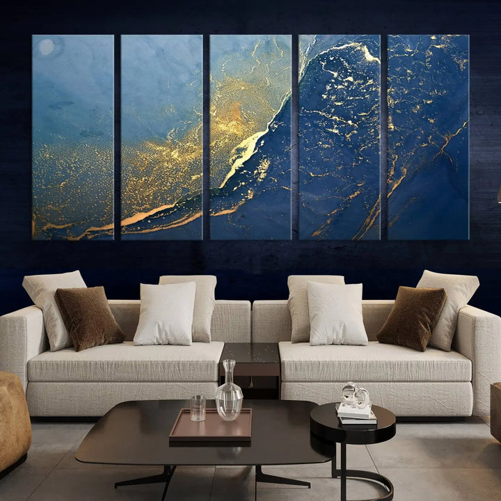 The Navy Blue Yellow Twinkle Wall Art Canvas Print, featuring an abstract design in gold and blue, enhances a modern living room as it adorns a white wall with its gallery-wrapped, museum-quality canvases for an exquisite touch.