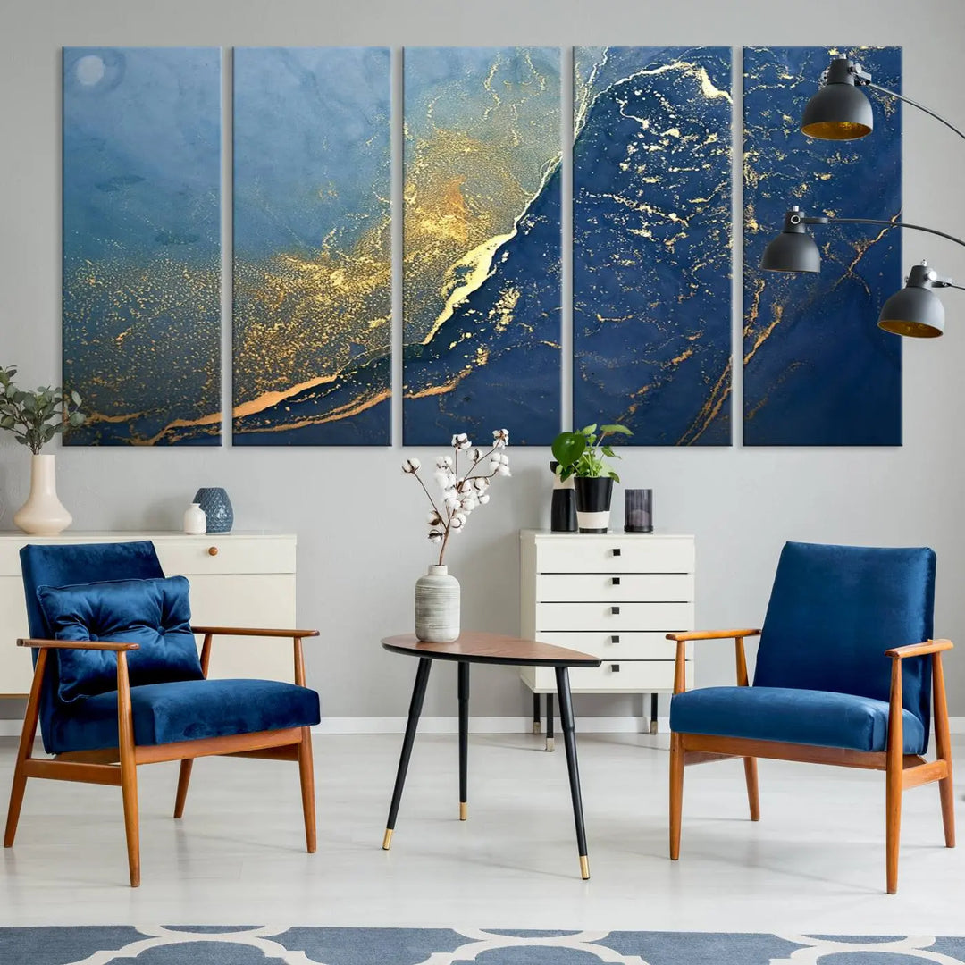 The Navy Blue Yellow Twinkle Wall Art Canvas Print, featuring an abstract design in gold and blue, enhances a modern living room as it adorns a white wall with its gallery-wrapped, museum-quality canvases for an exquisite touch.