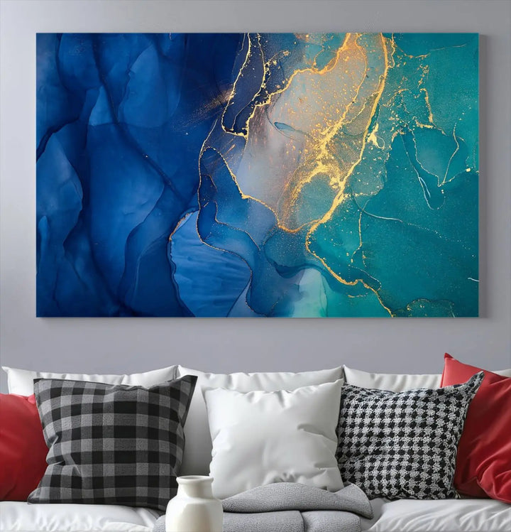 A Navy Blue and Green Marble Fluid Effect Wall Art Abstract Canvas Wall Art Print, featuring captivating patterns of blue and teal hues interlaced with gold veining, is ready to hang and protected by a UV-coating to preserve its vibrant colors over time.