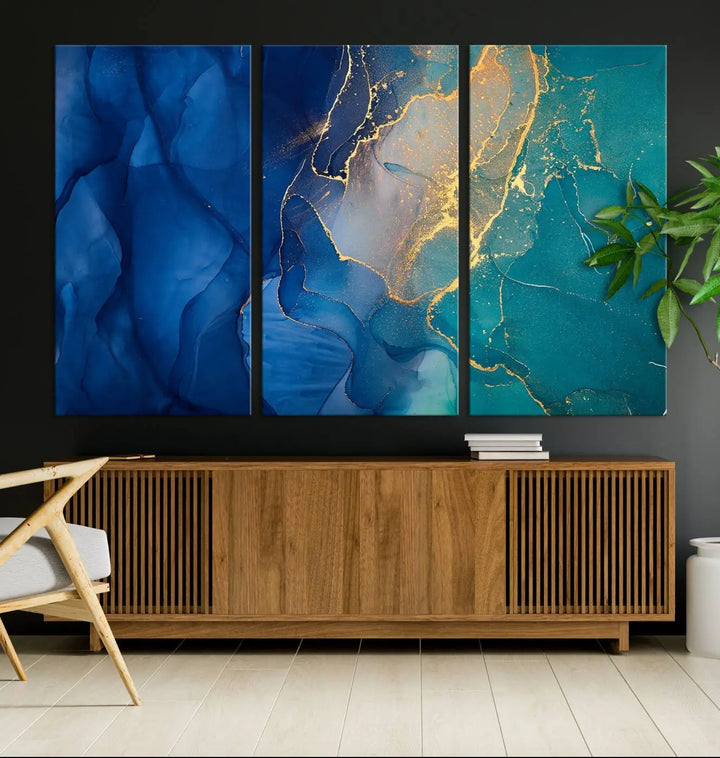 A Navy Blue and Green Marble Fluid Effect Wall Art Abstract Canvas Wall Art Print, featuring captivating patterns of blue and teal hues interlaced with gold veining, is ready to hang and protected by a UV-coating to preserve its vibrant colors over time.