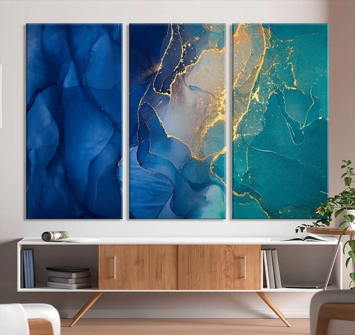 A Navy Blue and Green Marble Fluid Effect Wall Art Abstract Canvas Wall Art Print, featuring captivating patterns of blue and teal hues interlaced with gold veining, is ready to hang and protected by a UV-coating to preserve its vibrant colors over time.