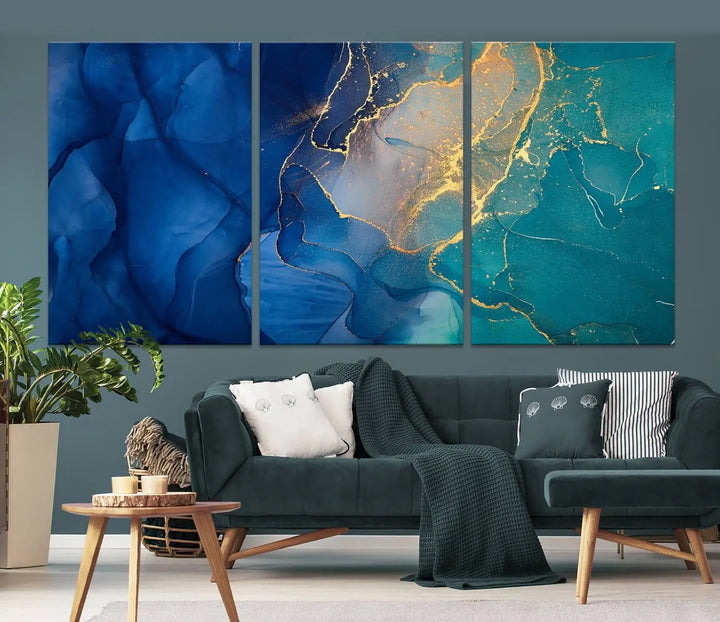 A Navy Blue and Green Marble Fluid Effect Wall Art Abstract Canvas Wall Art Print, featuring captivating patterns of blue and teal hues interlaced with gold veining, is ready to hang and protected by a UV-coating to preserve its vibrant colors over time.