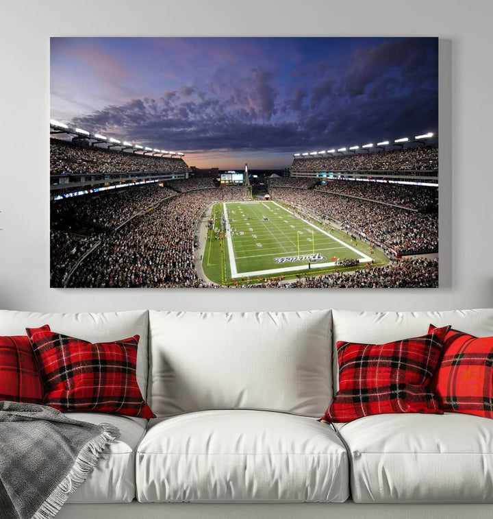 The living room showcases a remarkable set of canvases, the "New England Patriots Football Team Print - Foxborough Gillette Stadium Wall Art Canvas Print." This triptych captures a crowded football stadium at sunset, and each piece is coated with UV-protective layers to ensure lasting vibrancy. Additionally, you can enjoy the benefit of free shipping with your purchase.