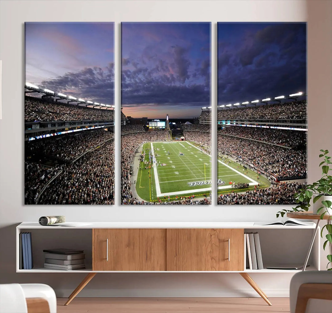 The living room showcases a remarkable set of canvases, the "New England Patriots Football Team Print - Foxborough Gillette Stadium Wall Art Canvas Print." This triptych captures a crowded football stadium at sunset, and each piece is coated with UV-protective layers to ensure lasting vibrancy. Additionally, you can enjoy the benefit of free shipping with your purchase.