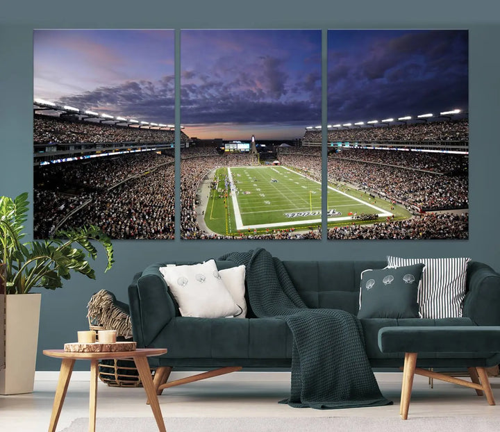 The living room showcases a remarkable set of canvases, the "New England Patriots Football Team Print - Foxborough Gillette Stadium Wall Art Canvas Print." This triptych captures a crowded football stadium at sunset, and each piece is coated with UV-protective layers to ensure lasting vibrancy. Additionally, you can enjoy the benefit of free shipping with your purchase.