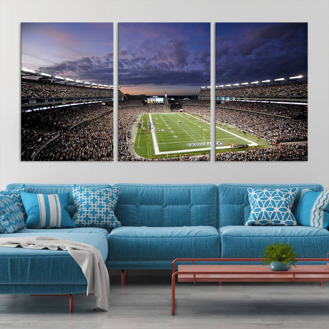 The living room showcases a remarkable set of canvases, the "New England Patriots Football Team Print - Foxborough Gillette Stadium Wall Art Canvas Print." This triptych captures a crowded football stadium at sunset, and each piece is coated with UV-protective layers to ensure lasting vibrancy. Additionally, you can enjoy the benefit of free shipping with your purchase.