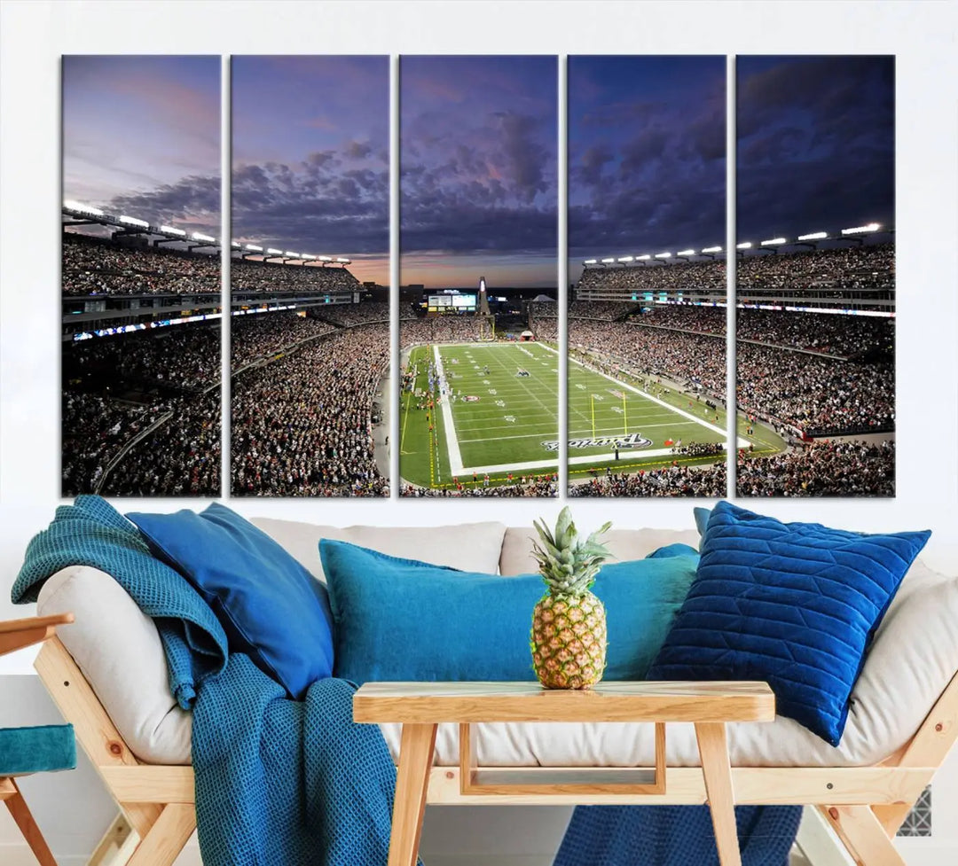 The living room showcases a remarkable set of canvases, the "New England Patriots Football Team Print - Foxborough Gillette Stadium Wall Art Canvas Print." This triptych captures a crowded football stadium at sunset, and each piece is coated with UV-protective layers to ensure lasting vibrancy. Additionally, you can enjoy the benefit of free shipping with your purchase.