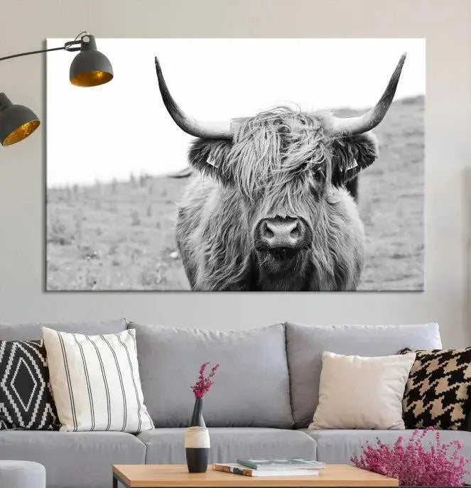 Newfoundland Cow Art Wall Art Canvas Print features a museum-quality, black-and-white triptych of a Highland cow with large horns, ideal for hanging on a dark wall.