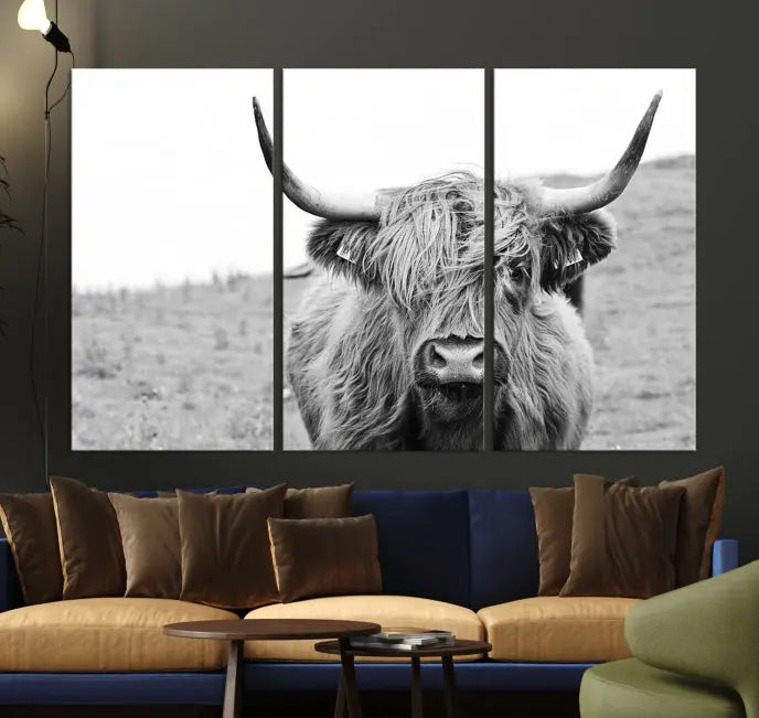 Newfoundland Cow Art Wall Art Canvas Print features a museum-quality, black-and-white triptych of a Highland cow with large horns, ideal for hanging on a dark wall.