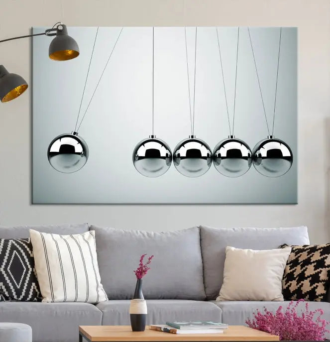 The contemporary living room features three Newton's Cradle Wall Art Canvas Prints on museum-quality polycotton canvas, each with gallery-wrapped edges for an enhanced finish.