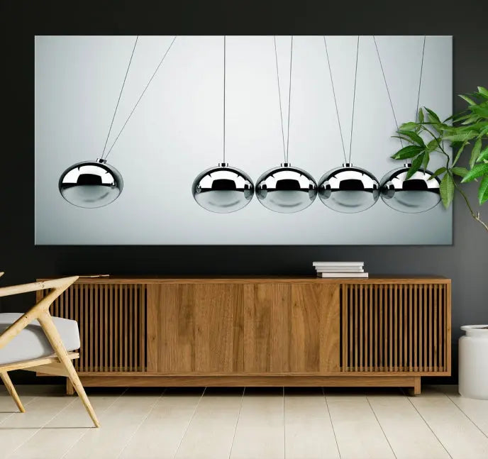 The contemporary living room features three Newton's Cradle Wall Art Canvas Prints on museum-quality polycotton canvas, each with gallery-wrapped edges for an enhanced finish.