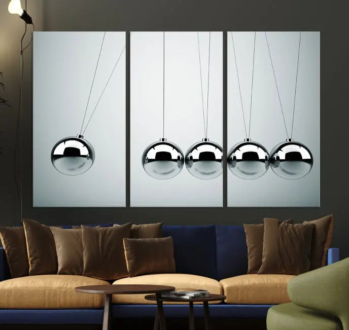 The contemporary living room features three Newton's Cradle Wall Art Canvas Prints on museum-quality polycotton canvas, each with gallery-wrapped edges for an enhanced finish.