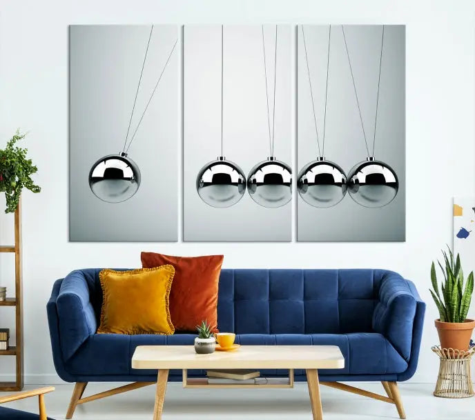 The contemporary living room features three Newton's Cradle Wall Art Canvas Prints on museum-quality polycotton canvas, each with gallery-wrapped edges for an enhanced finish.