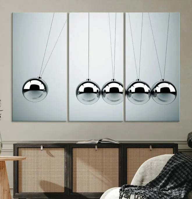 The contemporary living room features three Newton's Cradle Wall Art Canvas Prints on museum-quality polycotton canvas, each with gallery-wrapped edges for an enhanced finish.