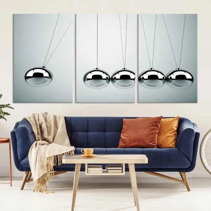 The contemporary living room features three Newton's Cradle Wall Art Canvas Prints on museum-quality polycotton canvas, each with gallery-wrapped edges for an enhanced finish.