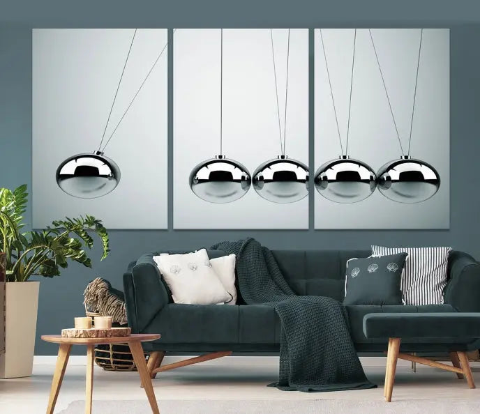 The contemporary living room features three Newton's Cradle Wall Art Canvas Prints on museum-quality polycotton canvas, each with gallery-wrapped edges for an enhanced finish.