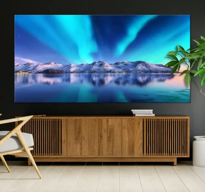 The room features the "Northern Lights above Mountain Wall Art Canvas Print," showcasing a triptych of the aurora borealis over snowy mountains and a lake. Professionally crafted frames on museum-quality canvases are highlighted in the modern decor.