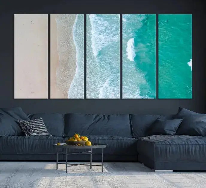 The space above the dark blue sofa is beautifully adorned with the Ocean Aerial Wall Art Canvas Print, featuring a breathtaking aerial beach view spread across five panels. Crafted on gallery-wrapped, museum-quality canvas with a UV-protective coating, it creates an impressive visual display.