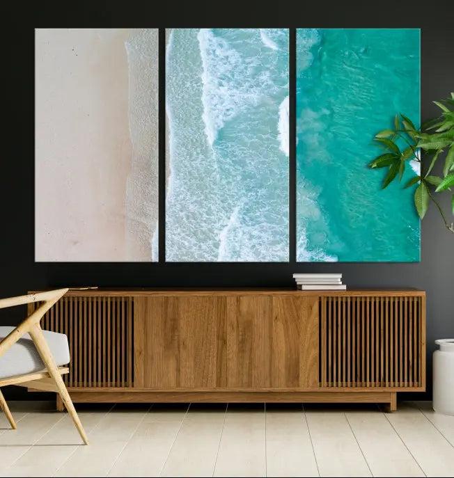 The space above the dark blue sofa is beautifully adorned with the Ocean Aerial Wall Art Canvas Print, featuring a breathtaking aerial beach view spread across five panels. Crafted on gallery-wrapped, museum-quality canvas with a UV-protective coating, it creates an impressive visual display.