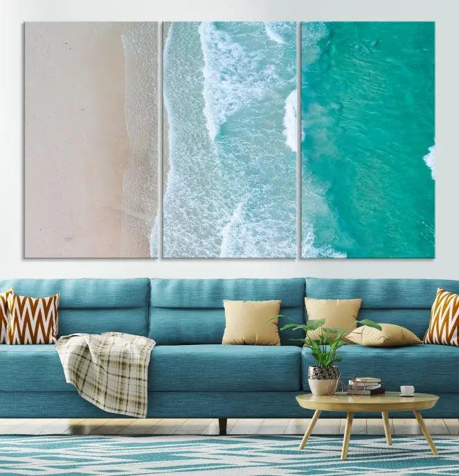 The space above the dark blue sofa is beautifully adorned with the Ocean Aerial Wall Art Canvas Print, featuring a breathtaking aerial beach view spread across five panels. Crafted on gallery-wrapped, museum-quality canvas with a UV-protective coating, it creates an impressive visual display.