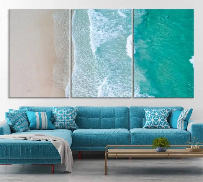 The space above the dark blue sofa is beautifully adorned with the Ocean Aerial Wall Art Canvas Print, featuring a breathtaking aerial beach view spread across five panels. Crafted on gallery-wrapped, museum-quality canvas with a UV-protective coating, it creates an impressive visual display.