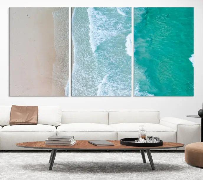 The space above the dark blue sofa is beautifully adorned with the Ocean Aerial Wall Art Canvas Print, featuring a breathtaking aerial beach view spread across five panels. Crafted on gallery-wrapped, museum-quality canvas with a UV-protective coating, it creates an impressive visual display.