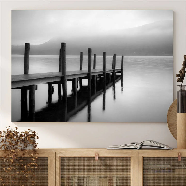 The "Ocean Beach Canvas Wall Art" is a black-and-white triptych depicting a serene dock over water.