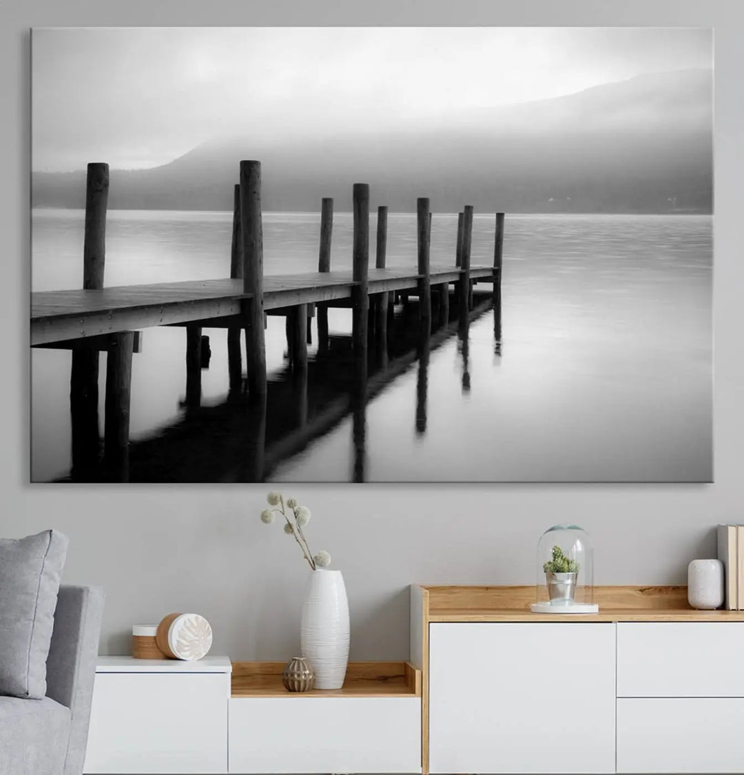 The "Ocean Beach Canvas Wall Art" is a black-and-white triptych depicting a serene dock over water.