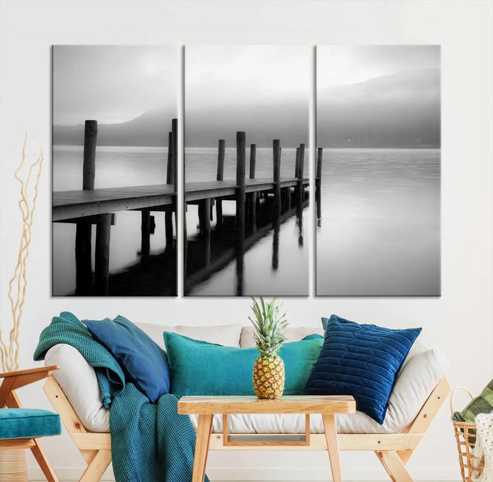 The "Ocean Beach Canvas Wall Art" is a black-and-white triptych depicting a serene dock over water.