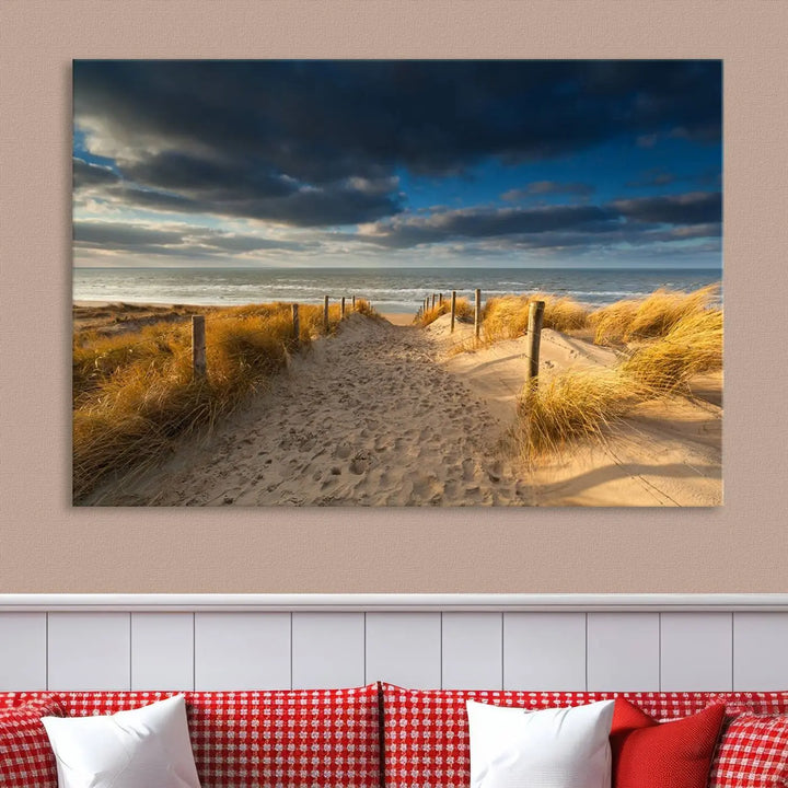 The Ocean Beach Dark Clouds Wall Art Canvas Print is a breathtaking triptych depicting a sandy beach path with tall grasses under an intense cloudy sky. It is crafted on museum-quality canvas with UV protection.