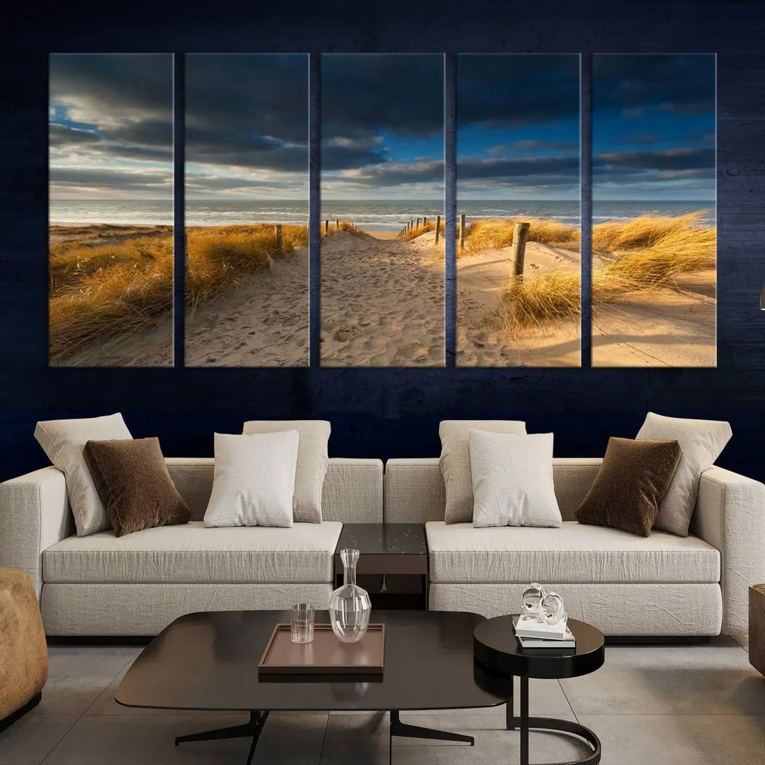 The Ocean Beach Dark Clouds Wall Art Canvas Print is a breathtaking triptych depicting a sandy beach path with tall grasses under an intense cloudy sky. It is crafted on museum-quality canvas with UV protection.