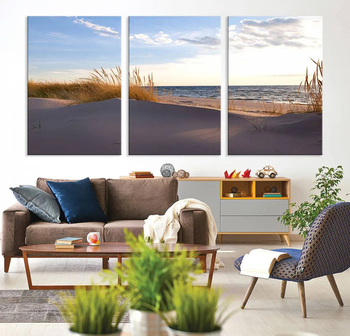 The living room showcases the Ocean Beach Wall Art Canvas Print Sunset Artwork Print Coastal Wall Art—a triptych wall art featuring a beach scene at sunset. Each museum-quality canvas piece is ready to hang and includes a UV-protective coating to preserve its stunning beauty.