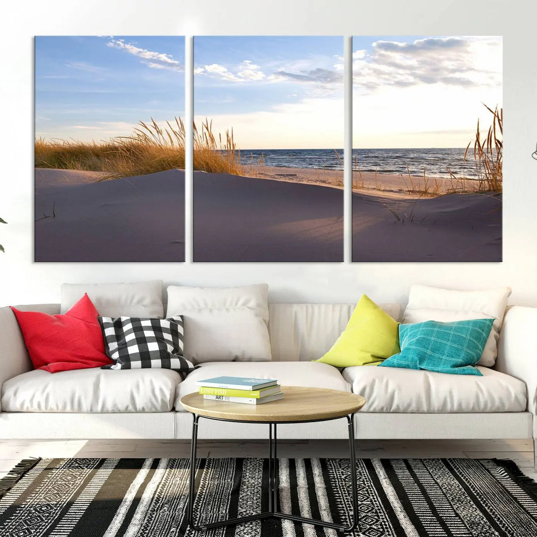 The living room showcases the Ocean Beach Wall Art Canvas Print Sunset Artwork Print Coastal Wall Art—a triptych wall art featuring a beach scene at sunset. Each museum-quality canvas piece is ready to hang and includes a UV-protective coating to preserve its stunning beauty.