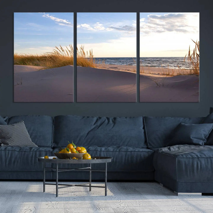 The living room showcases the Ocean Beach Wall Art Canvas Print Sunset Artwork Print Coastal Wall Art—a triptych wall art featuring a beach scene at sunset. Each museum-quality canvas piece is ready to hang and includes a UV-protective coating to preserve its stunning beauty.