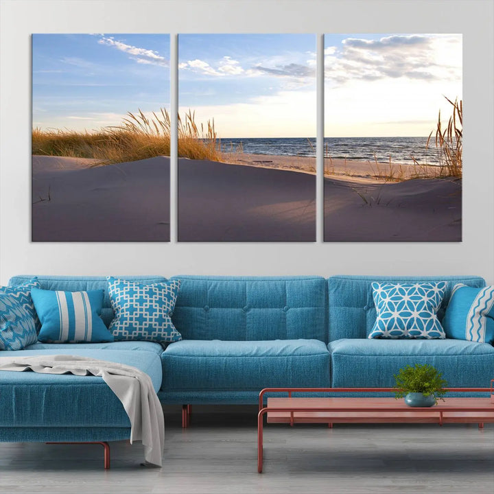 The living room showcases the Ocean Beach Wall Art Canvas Print Sunset Artwork Print Coastal Wall Art—a triptych wall art featuring a beach scene at sunset. Each museum-quality canvas piece is ready to hang and includes a UV-protective coating to preserve its stunning beauty.