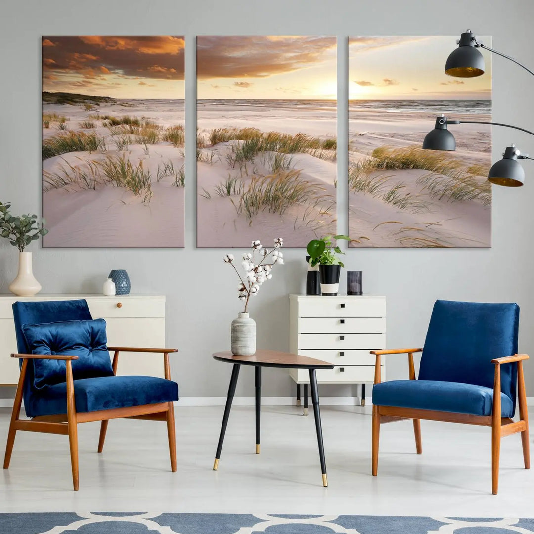 A triptych of the Ocean Beach Wall Art Canvas Print Sunset Artwork Print Coastal Wall Art showcases a serene beach landscape with sand dunes and grasses, gallery wrapped on museum-quality canvas.