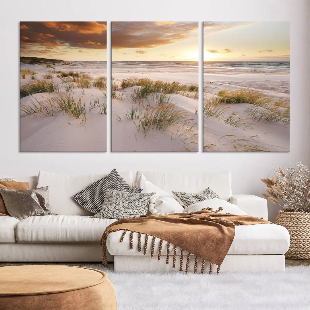 A triptych of the Ocean Beach Wall Art Canvas Print Sunset Artwork Print Coastal Wall Art showcases a serene beach landscape with sand dunes and grasses, gallery wrapped on museum-quality canvas.