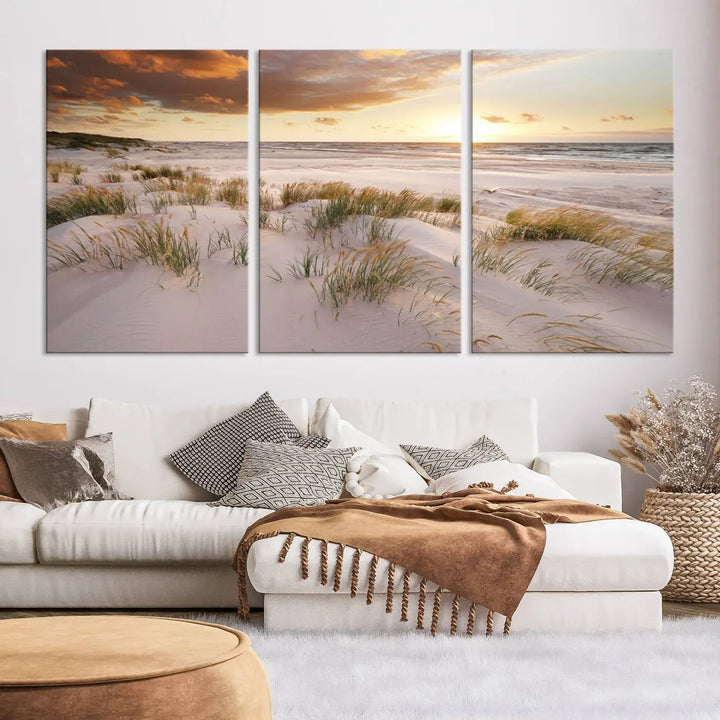 A triptych of the Ocean Beach Wall Art Canvas Print Sunset Artwork Print Coastal Wall Art showcases a serene beach landscape with sand dunes and grasses, gallery wrapped on museum-quality canvas.