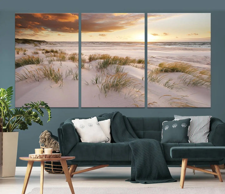 A triptych of the Ocean Beach Wall Art Canvas Print Sunset Artwork Print Coastal Wall Art showcases a serene beach landscape with sand dunes and grasses, gallery wrapped on museum-quality canvas.