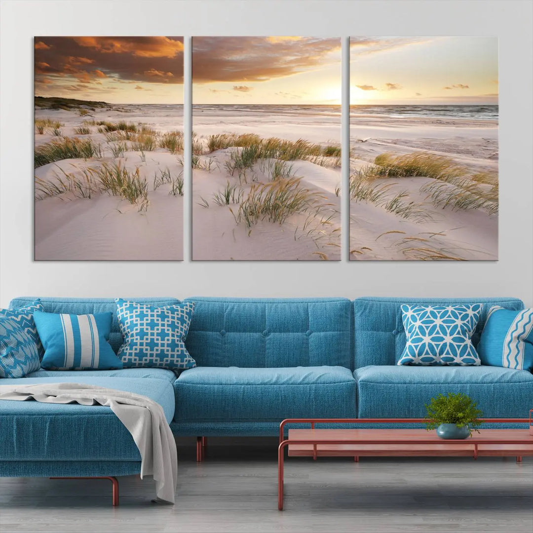 A triptych of the Ocean Beach Wall Art Canvas Print Sunset Artwork Print Coastal Wall Art showcases a serene beach landscape with sand dunes and grasses, gallery wrapped on museum-quality canvas.