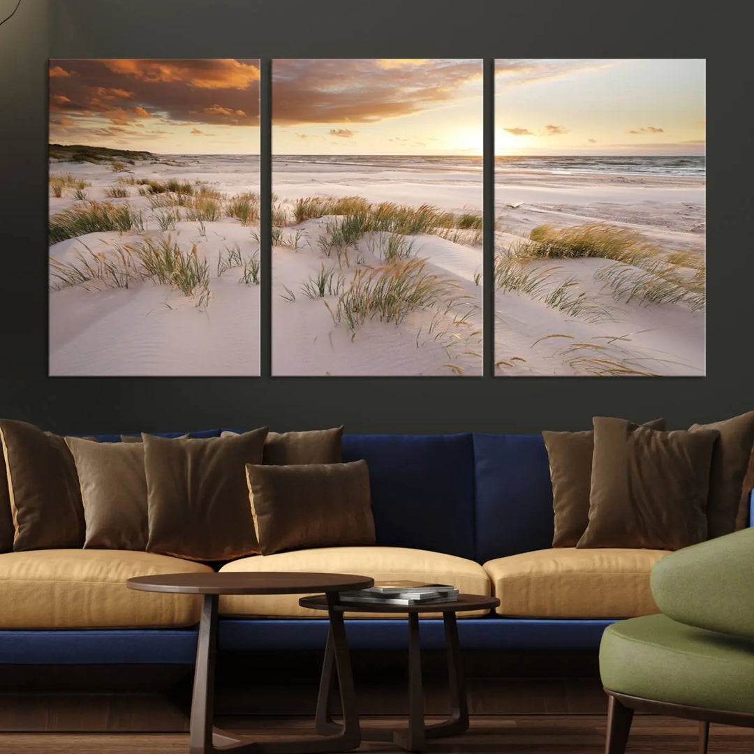 A triptych of the Ocean Beach Wall Art Canvas Print Sunset Artwork Print Coastal Wall Art showcases a serene beach landscape with sand dunes and grasses, gallery wrapped on museum-quality canvas.