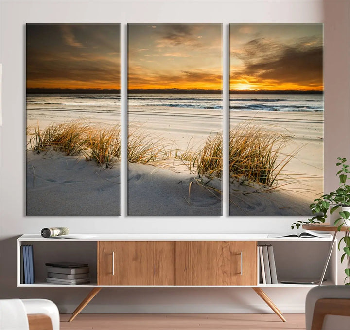 The Ocean Beach Wall Art Canvas Print, a captivating triptych showcasing a sunset over the beach with grass, hangs gracefully. These gallery-wrapped, museum-quality canvases boast a UV-protective coating that preserves their vibrant colors and stunning detail for years to come.