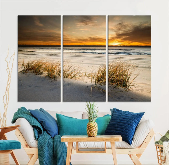 The Ocean Beach Wall Art Canvas Print, a captivating triptych showcasing a sunset over the beach with grass, hangs gracefully. These gallery-wrapped, museum-quality canvases boast a UV-protective coating that preserves their vibrant colors and stunning detail for years to come.